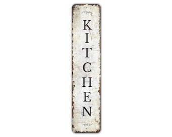 May include: A white vertical sign with distressed paint and black lettering that reads "KITCHEN".