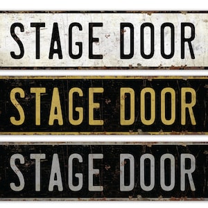 May include: Three vintage-style metal signs with the text "STAGE DOOR" in black, gold, and silver lettering on a black background.