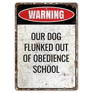 May include: A white metal sign with black and red text that reads "Warning Our Dog Flunked Out Of Obedience School". The sign has a distressed, rusty look.