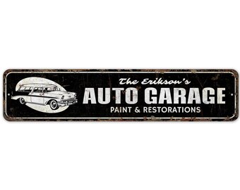 May include: A black and white vintage style metal sign with a rusty effect. The sign reads "The Erikson's Auto Garage. Paint & Restorations." and features a black and white illustration of a classic car.