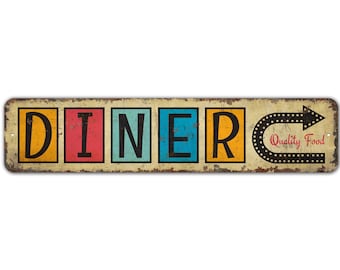 Puede incluir: Un letrero de metal de estilo vintage con la palabra "DINER" en letras de colores y una flecha que apunta hacia la derecha. El letrero también dice "Quality Food" en letras rojas.