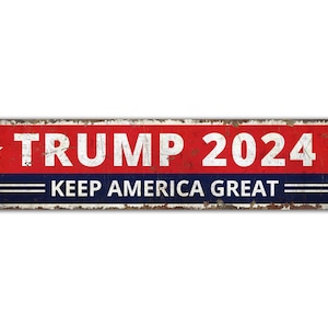 May include: A red, white, and blue metal sign with the text "TRUMP 2024" and "KEEP AMERICA GREAT" in white lettering.