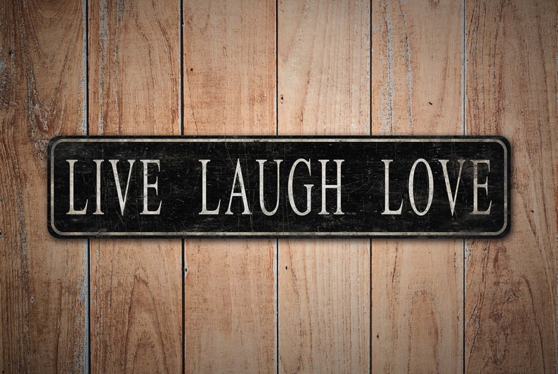 May include: Black wooden sign with white text that reads "LIVE LAUGH LOVE" on a woodgrain background.
