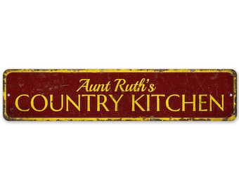 May include: A red metal sign with yellow text that reads "Aunt Ruth's Country Kitchen".
