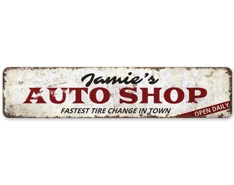 May include: A white metal sign with red text that reads "Jamie's Auto Shop" with the tagline "Fastest Tire Change in Town" and "Open Daily".