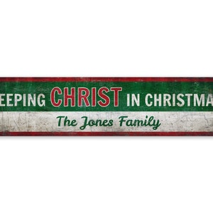 May include: A red, white, and green metal sign with the text "KEEPING CHRIST IN CHRISTMAS" in red and green lettering. The text "The Jones Family" is written in green lettering below the main text.