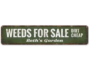 May include: A green metal sign with the text "WEEDS FOR SALE DIRT CHEAP" in white letters. The sign also has the text "Beth's Garden" in white letters.