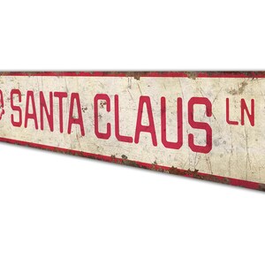 a red and white sign that says santa claus