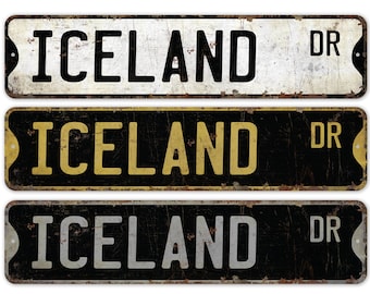 May include: Three vintage-style metal street signs with the text "ICELAND DR" in black, gold, and white lettering on a black, white, and black background, respectively.