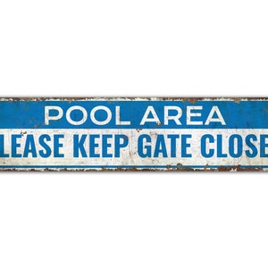 May include: A blue and white metal sign with the text "POOL AREA PLEASE KEEP GATE CLOSED". The sign has a distressed, rusty look.