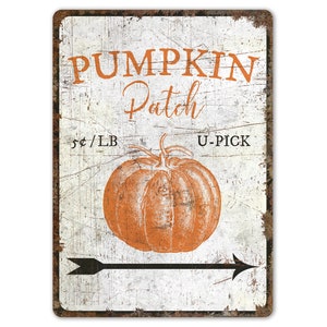 Könnte beinhalten: Ein weißes Metallschild mit einem abgenutzten Look, mit einem Kürbisfeld-Schild mit dem Text "Pumpkin Patch", "5¢/LB" und "U-PICK". In der Mitte des Schildes befindet sich eine Zeichnung eines orangefarbenen Kürbisses. Ein schwarzer Pfeil zeigt nach rechts.
