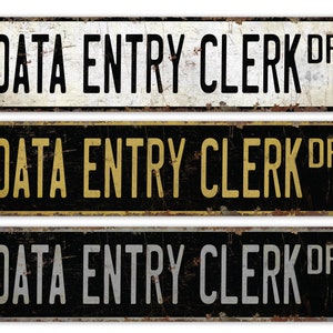 May include: Three vintage-style metal signs with the text "DATA ENTRY CLERK DR" in black, gold, and silver lettering on a black background.