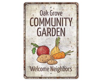May include: A white metal sign with a distressed look, featuring the text "Oak Grove Community Garden" in brown lettering. The sign also includes a drawing of a red beet, a yellow onion, and an orange carrot, along with the text "Welcome Neighbors".
