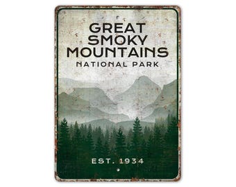May include: A vintage-style metal sign with a rustic background featuring a scenic view of the Great Smoky Mountains National Park. The sign reads "Great Smoky Mountains National Park Est. 1934".
