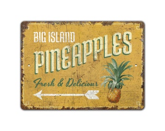 May include: A yellow and green vintage-style metal sign with the text "Big Island Pineapples Fresh & Delicious" and an arrow pointing to the right. A pineapple is pictured on the right side of the sign.