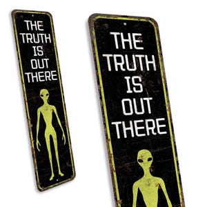 a sign with a picture of an alien and the words the truth is out there