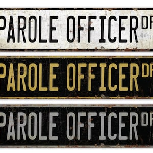 May include: Three vintage-style metal signs with the text "PAROLE OFFICER DR" in black, gold, and silver lettering on a black background.