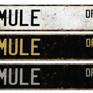 May include: Three vintage-style metal signs with the text "Mule Dr." in black, yellow, and white lettering on a black and white background.