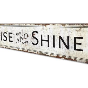 a rusted metal sign that says rise and shine