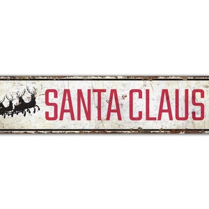 a santa claus tin sign on a white background