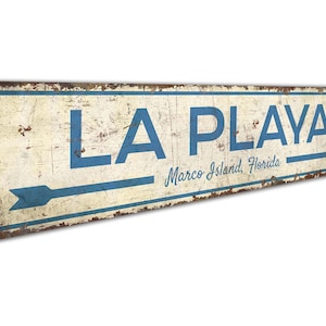 a sign that says la playa with an arrow pointing to the right