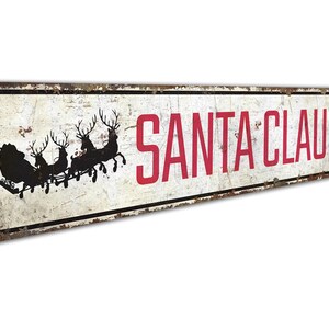 a metal sign that says santa claus on it