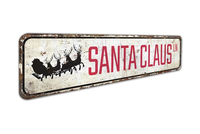 a metal sign that says santa claus on it