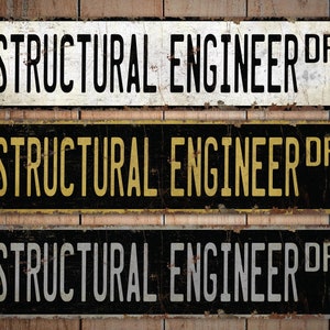 Pode incluir: Tr&ecirc;s placas de metal de estilo vintage com o texto "STRUCTURAL ENGINEER DR" em letras pretas, douradas e brancas sobre um fundo preto, branco e preto, respectivamente. As placas t&ecirc;m um aspecto desgastado e enferrujado.