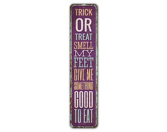 May include: Purple metal sign with white, blue, and orange text that reads "Trick or Treat Smell My Feet Give Me Something Good To Eat".