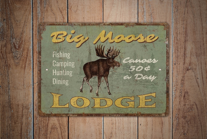 May include: A vintage-style metal sign with a rustic green background and yellow text. The sign reads "Big Moose Lodge" and features a moose illustration. It lists services offered: fishing, camping, hunting, dining, and canoe rentals for $50 a day.