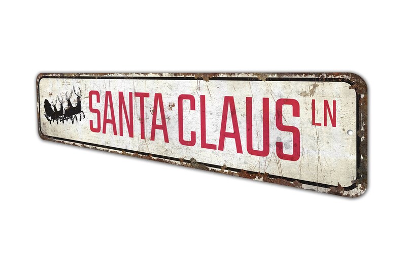 a sign that says santa claus in red on a white background