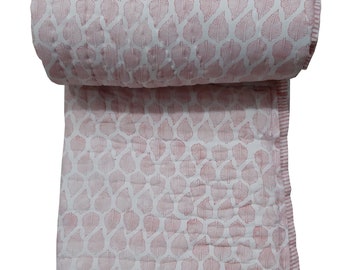 May include: A pink and white cotton quilt with a leaf pattern. The quilt is rolled up and has a white border.