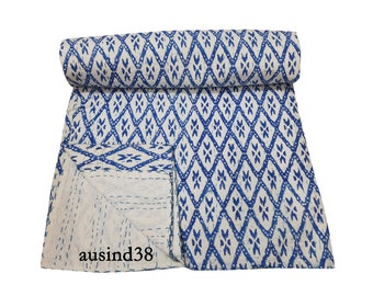 May include: A white and blue kantha quilt with a diamond pattern. The quilt is folded in half and has a small tag that says "ausind38".