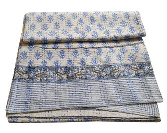 May include: A white and blue kantha quilt with a floral pattern. The quilt is folded in half and has a striped border.