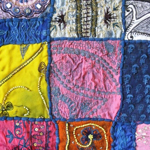 Peut inclure: Une courtepointe color&eacute;e en patchwork avec diff&eacute;rents motifs et textures, y compris des motifs floraux, des formes g&eacute;om&eacute;triques et des accents perl&eacute;s. La courtepointe est compos&eacute;e de diff&eacute;rents tissus dans des tons de bleu, rose, jaune, orange et blanc.