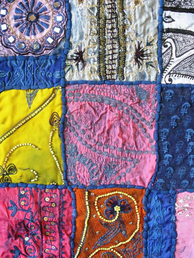 Peut inclure: Une courtepointe color&eacute;e en patchwork avec diff&eacute;rents motifs et textures, y compris des motifs floraux, des formes g&eacute;om&eacute;triques et des accents perl&eacute;s. La courtepointe est compos&eacute;e de diff&eacute;rents tissus dans des tons de bleu, rose, jaune, orange et blanc.