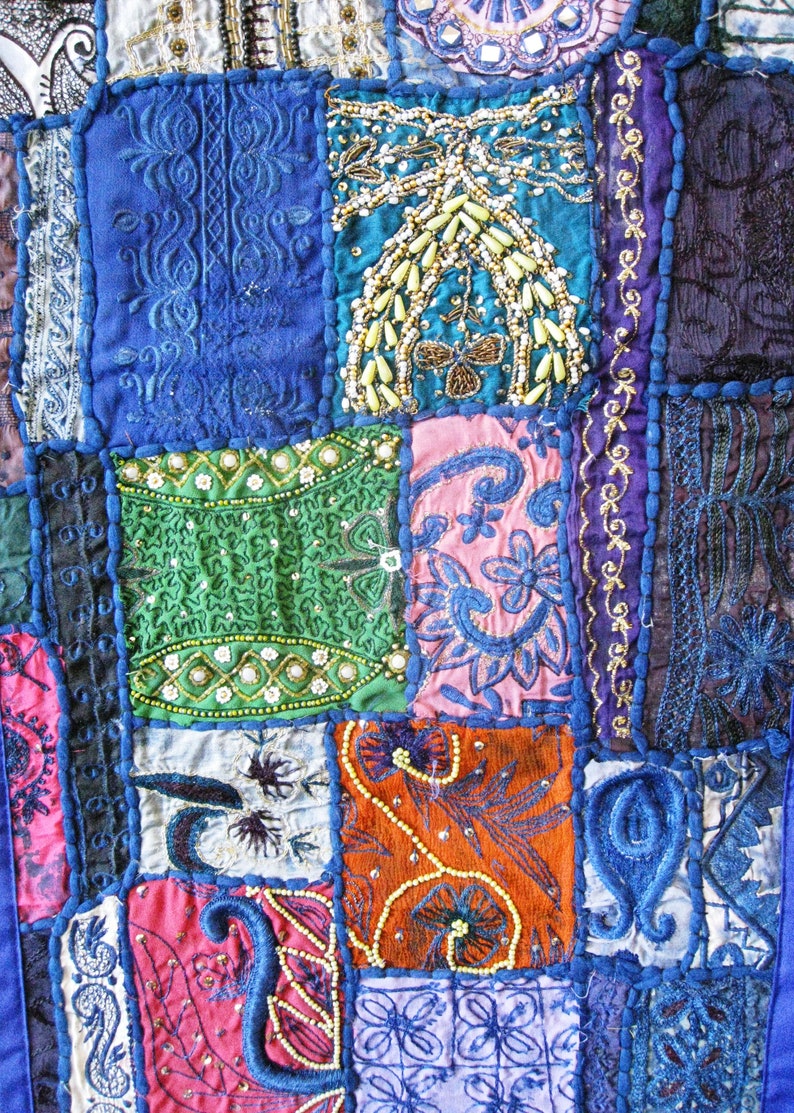 Peut inclure: Une courtepointe patchwork avec une vari&eacute;t&eacute; de couleurs et de motifs, notamment du bleu, du vert, du rose et de l'orange. La courtepointe est faite de diff&eacute;rents tissus et textures, et pr&eacute;sente des broderies et des perles complexes.