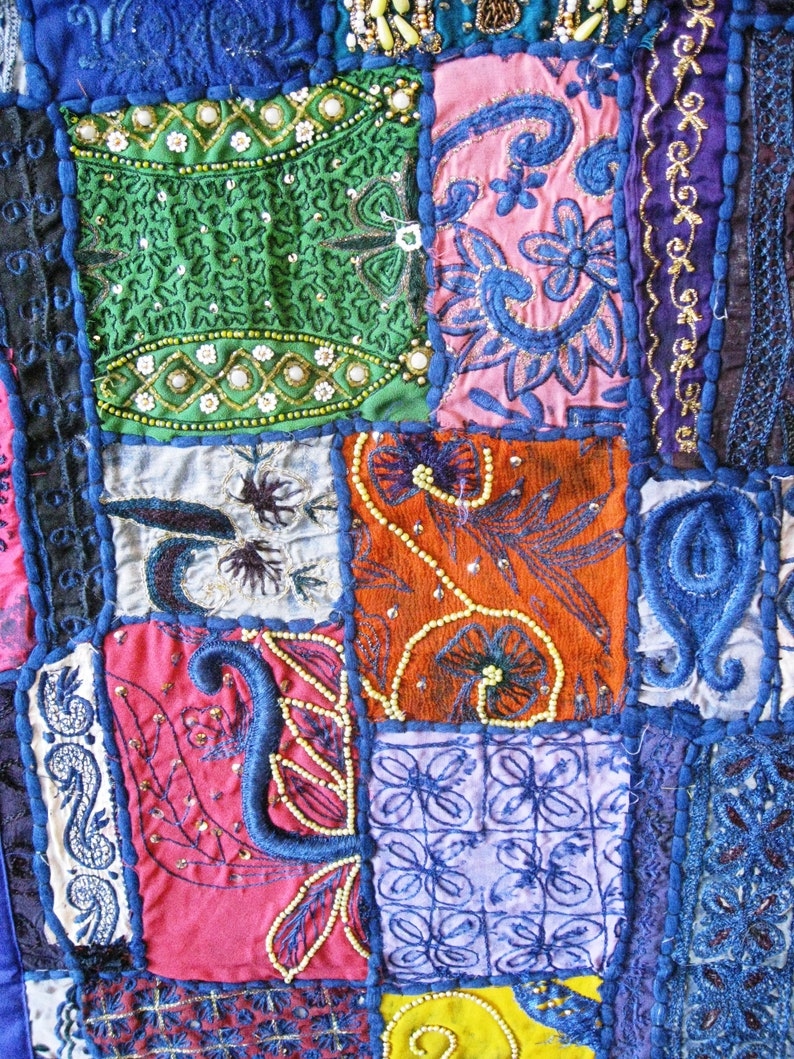 Peut inclure: Une courtepointe color&eacute;e en patchwork avec des broderies et des perles complexes. La courtepointe est compos&eacute;e de diff&eacute;rents tissus dans des tons de bleu, vert, rouge, orange et rose. La courtepointe est un bel exemple de l'artisanat indien traditionnel.