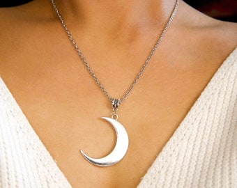 May include: A silver chain necklace with a crescent moon pendant.