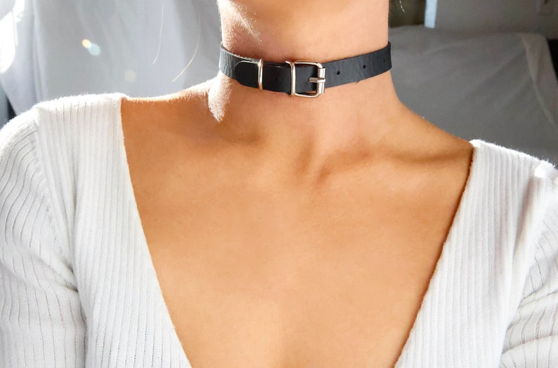 Pu&ograve; includere: Un choker in pelle nera con una fibbia argentata.