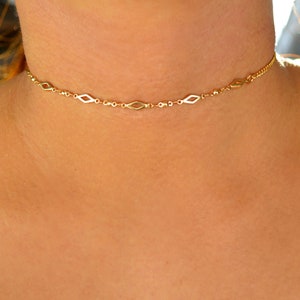 Pode incluir: Um colar gargantilha de corrente dourada com um delicado design em forma de diamante. O colar &eacute; simples e elegante, perfeito para o uso di&aacute;rio.