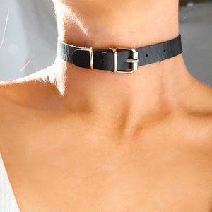 Pu&ograve; includere: Un choker in pelle nera con una fibbia argentata.