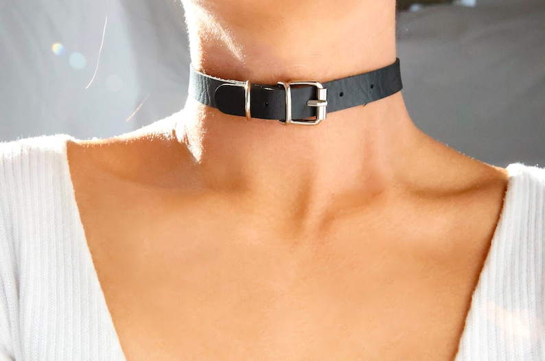 Pu&ograve; includere: Un choker in pelle nera con una fibbia argentata.