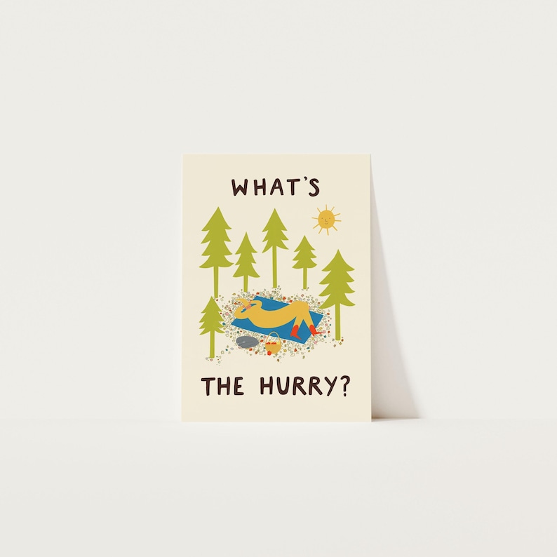 May include: A cream-colored greeting card featuring a cartoon illustration of a yellow figure relaxing on a blue blanket under green pine trees. The text WHAT'S THE HURRY? is printed in brown, with a small yellow sun and a basket nearby.