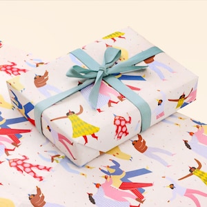 Puede incluir: Un papel de regalo blanco con una cinta azul y un patrón de personas bailando. Las personas llevan ropa colorida y sombreros de fiesta. Hay confeti y serpentinas en el fondo.