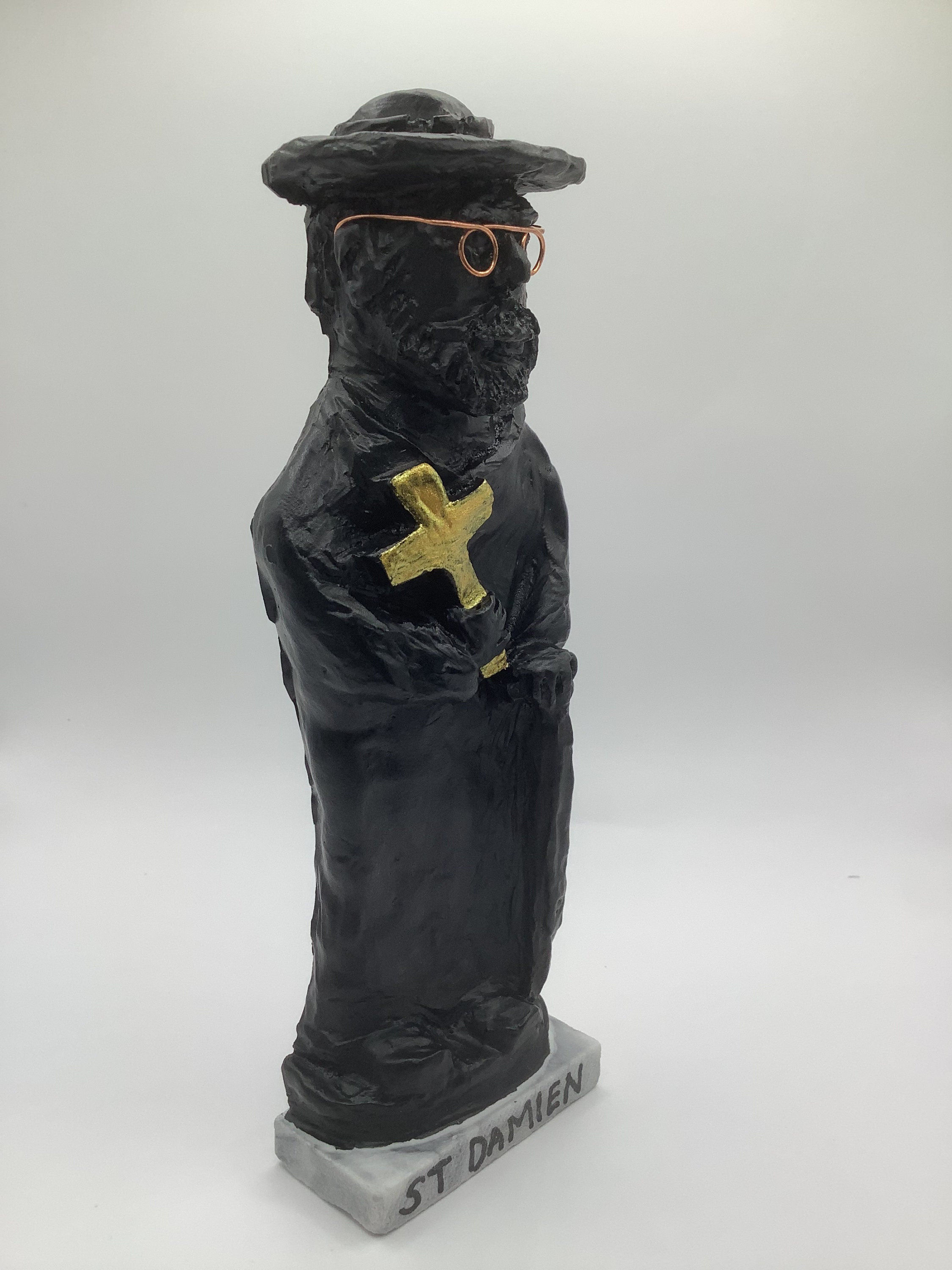 St Damien of Molokai Statue, Lava Rock Black W/ Golden Cross on a