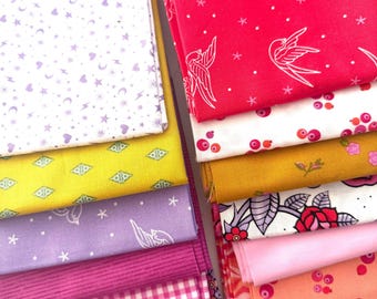 May include: A collection of folded fabric squares featuring various patterns including white swallows on red, pink gingham, floral motifs, geometric shapes, stars, moons, and hearts in a palette of red, pink, yellow, purple, and white.