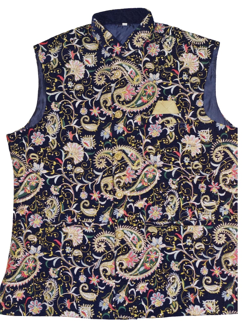 Op de afbeelding: Een marineblauwe vest met een paisley patroon in goud, roze en groen. De vest heeft een opstaande kraag en een kleine zak met een gouden rand. De mouwloze vest is volledig gevoerd.