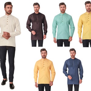 May include: A collection of long-sleeved tunic shirts in various colors, including cream, brown, mint green, yellow, and blue. Each shirt features a mandarin collar, a button-down placket, and a chest pocket. The shirts are paired with dark denim jeans.