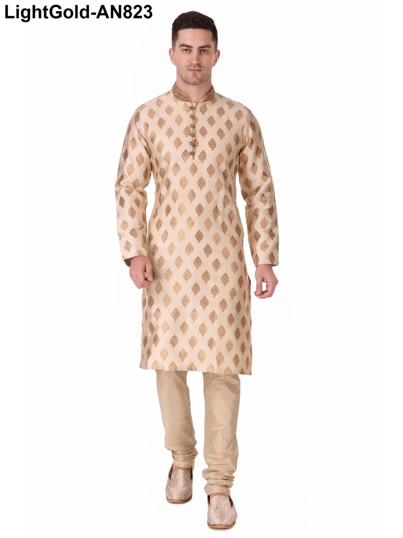 May include: A light gold kurta pajama set. The long-sleeved kurta features a mandarin collar and a repeating gold leaf pattern. The matching pajama pants and shoes complete the ensemble. The text "LightGold-AN823" is in the top left corner.